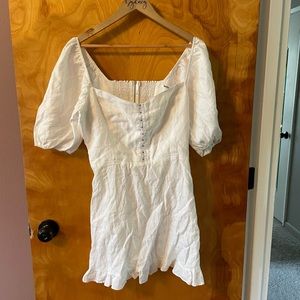 White linen mini dress with puff sleeves and ruched back.